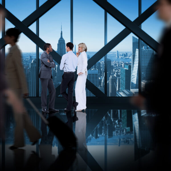 Business colleagues talking against room with large window looking on city